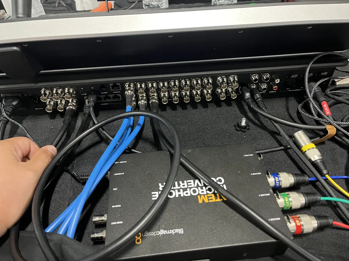 Hand routing audio and Ethernet cables into the back of a video switcher
