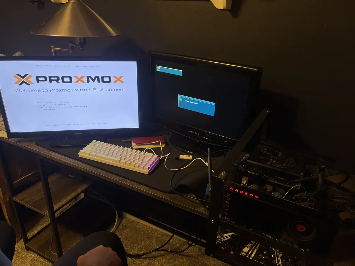 Custom-built desktop PC on an open test bench with a Radeon graphics card, booting the Proxmox installer
